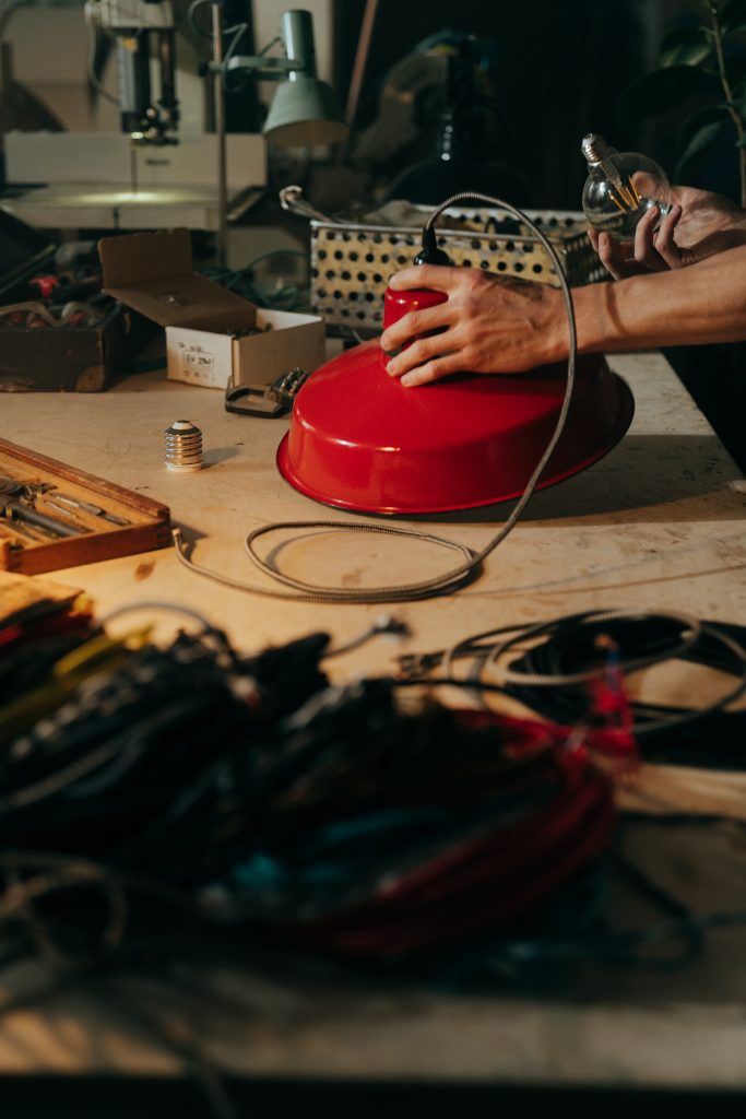 Eine rote Lampe liegt auf einem Werkstatttisch